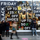 Shoppers walk past a store promoting "Black Friday" in London, Britain November 27, 2016. REUTERS/Peter Nicholls - LR1ECBR1B5AK2